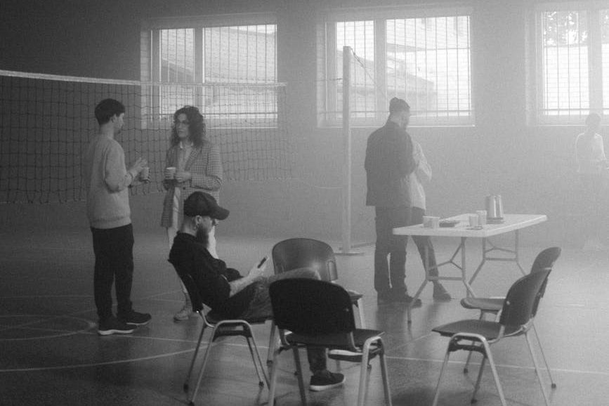 grayscale photo of people sitting on chairs